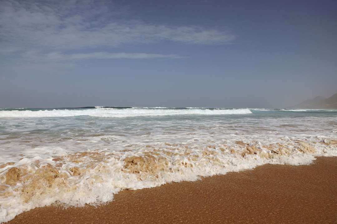 океанські хвилі, що розбиваються на берег вдень онлайн пазл