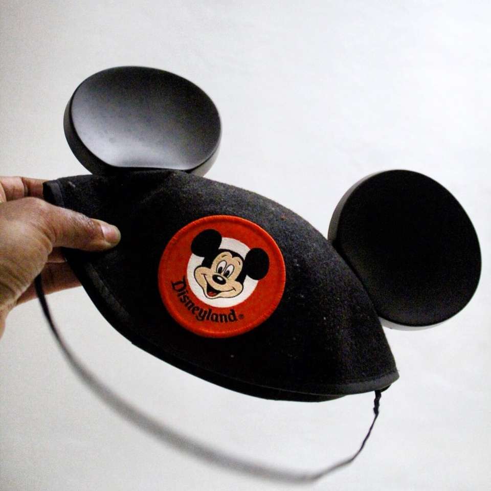 pessoa segurando boné do Mickey Mouse quebra-cabeças online