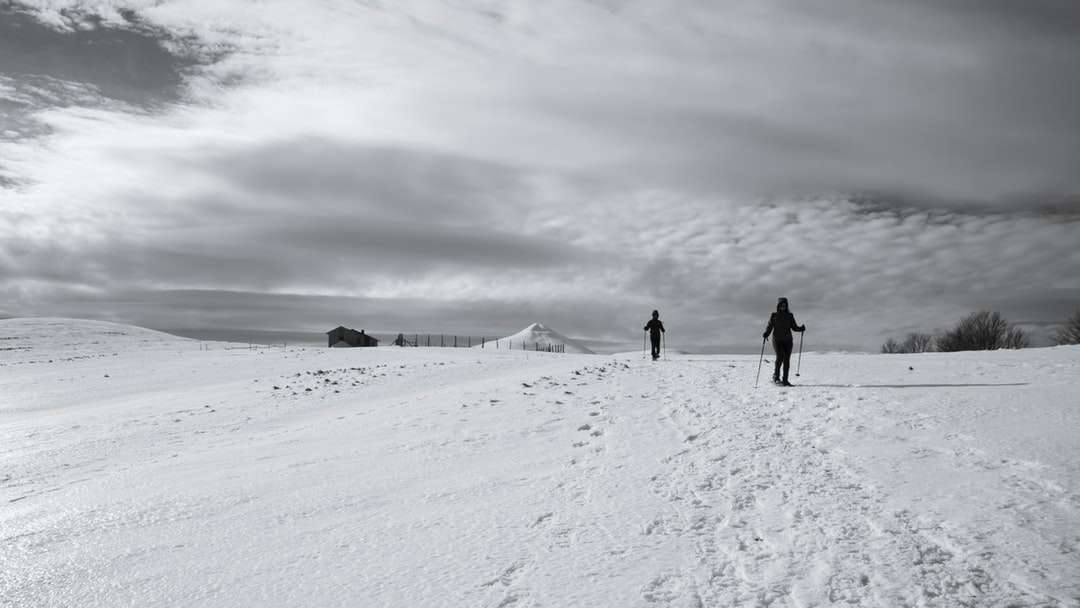 2 személy napközben havas talajon sétál kirakós online