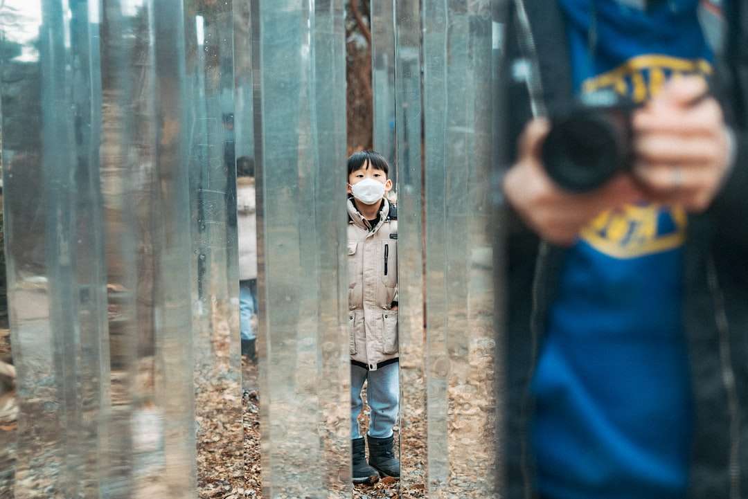 chlapec v modré košili a šedých kalhotách stojící vedle dřevěné stěny skládačky online