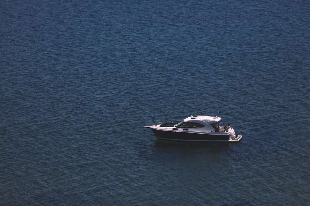 barca cu motor alb și negru pe mare albastră în timpul zilei jigsaw puzzle online