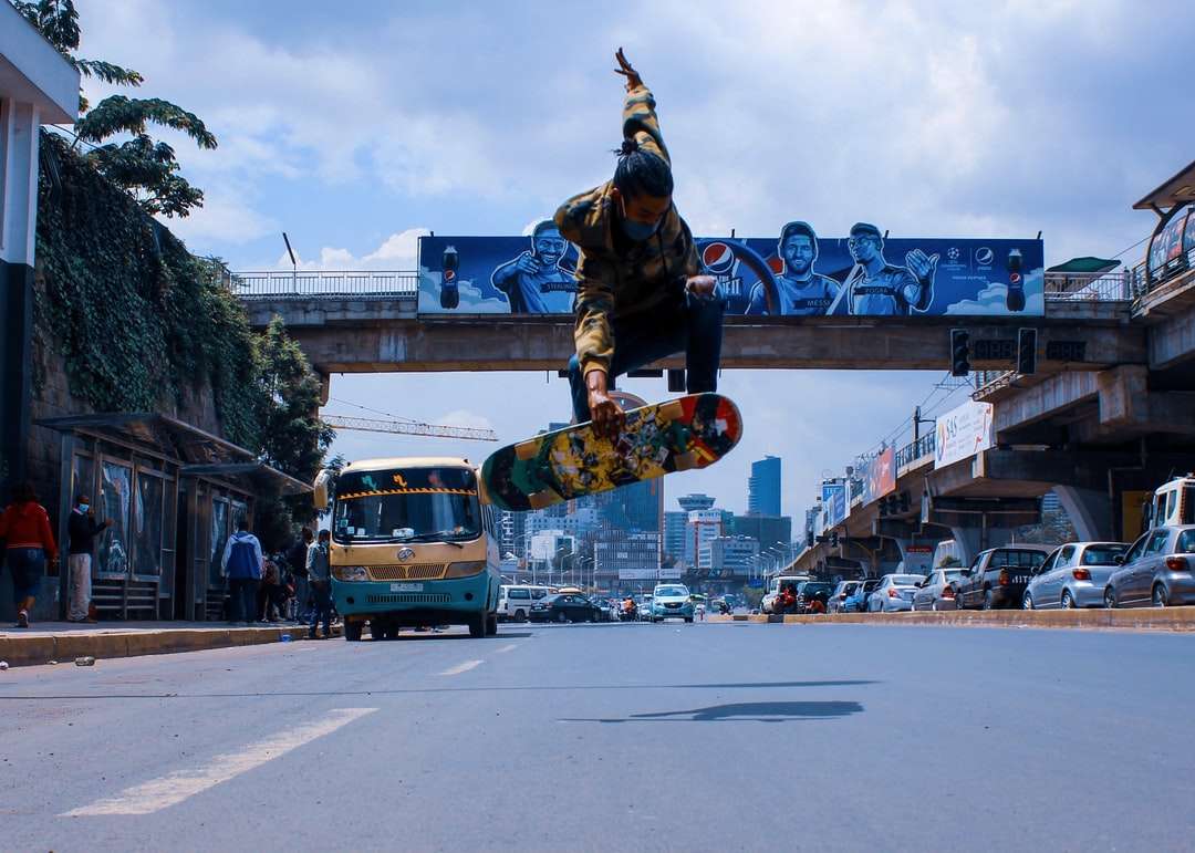 άντρας με μαύρο σακάκι και παντελόνι ιππασίας skateboard στο δρόμο παζλ online