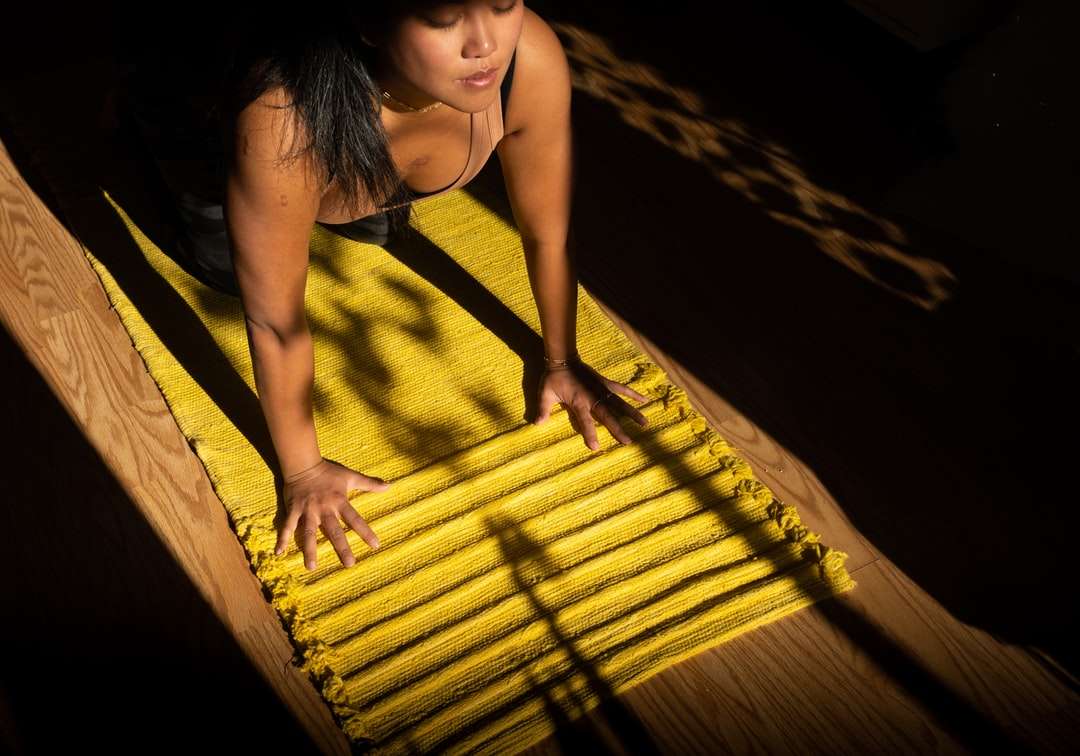 Mujer en camiseta amarilla de pie sobre un muelle de madera marrón rompecabezas en línea
