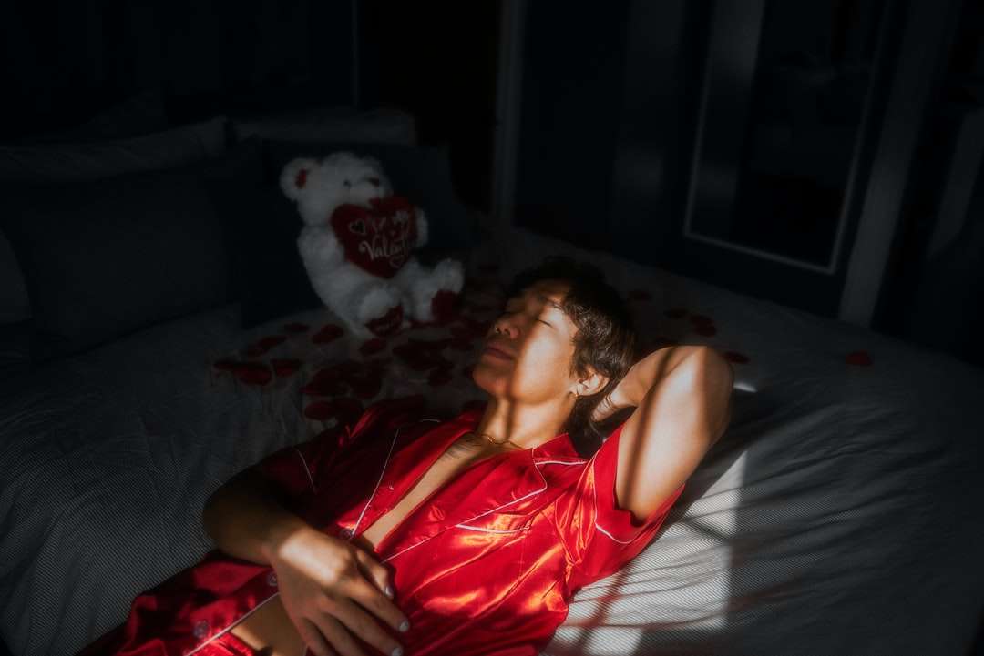 κορίτσι στο κόκκινο φανελάκι ξαπλωμένη στο κρεβάτι παζλ online