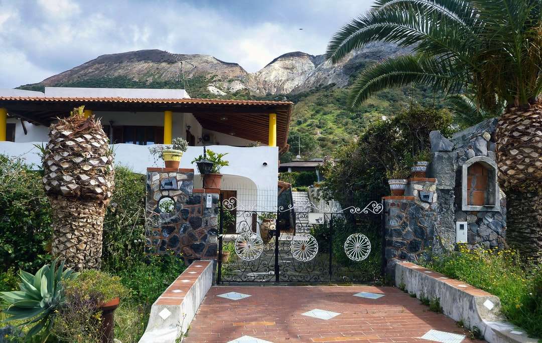 casa de concreto branco e marrom perto de palmeiras verdes quebra-cabeças online