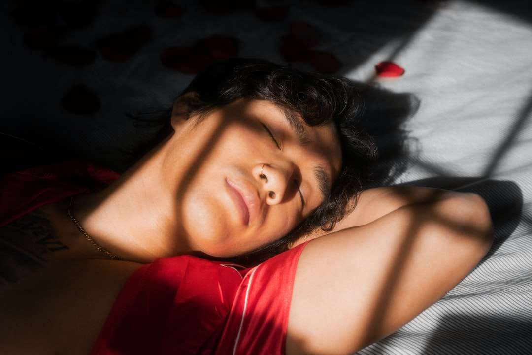 mulher de blusa vermelha e branca deitada na cama quebra-cabeças online