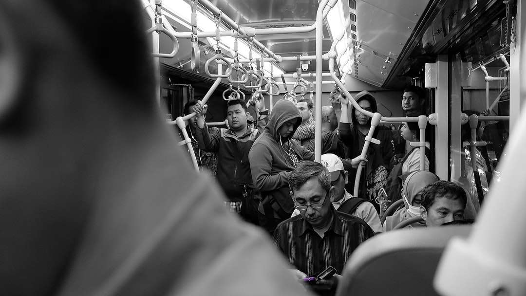 foto en escala de grises de personas en tren rompecabezas en línea