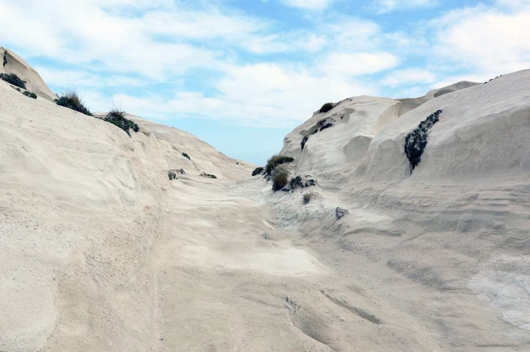 Person, die auf weißem schneebedecktem Berg steht Online-Puzzle