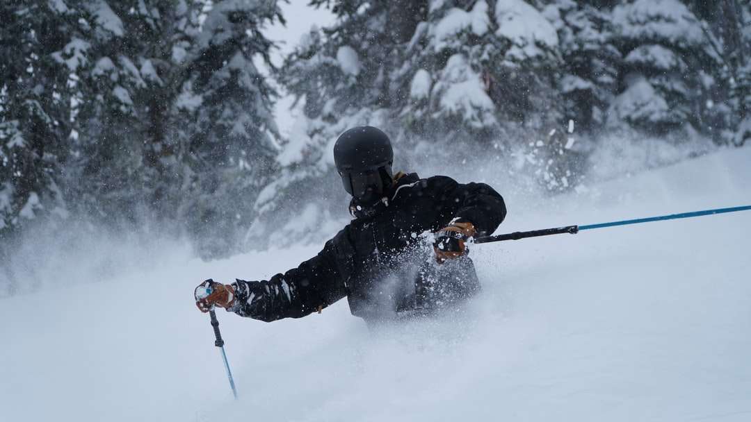 homem de jaqueta preta e calça preta andando com lâminas de esqui puzzle online