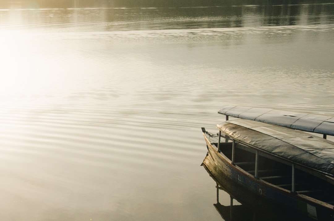 коричневая деревянная лодка на спокойной воде в дневное время онлайн-пазл