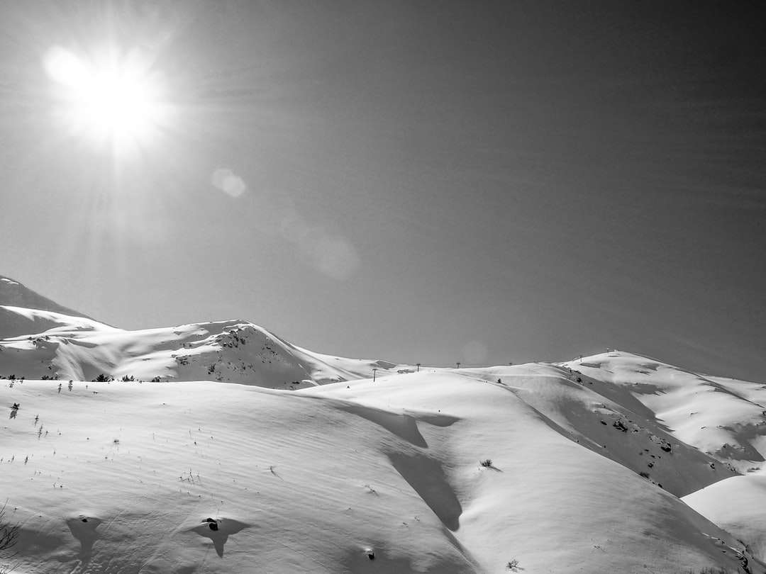 montagna coperta di neve sotto il cielo soleggiato puzzle online
