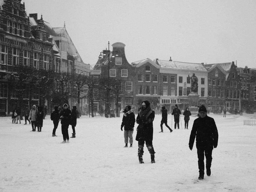Les gens qui marchent sur un sol couvert de neige près du bâtiment puzzle en ligne