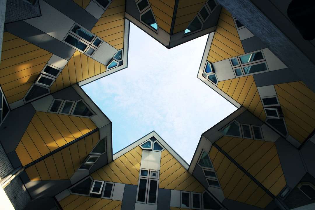 Fotografía de ángulo bajo de edificio de hormigón blanco y marrón rompecabezas en línea