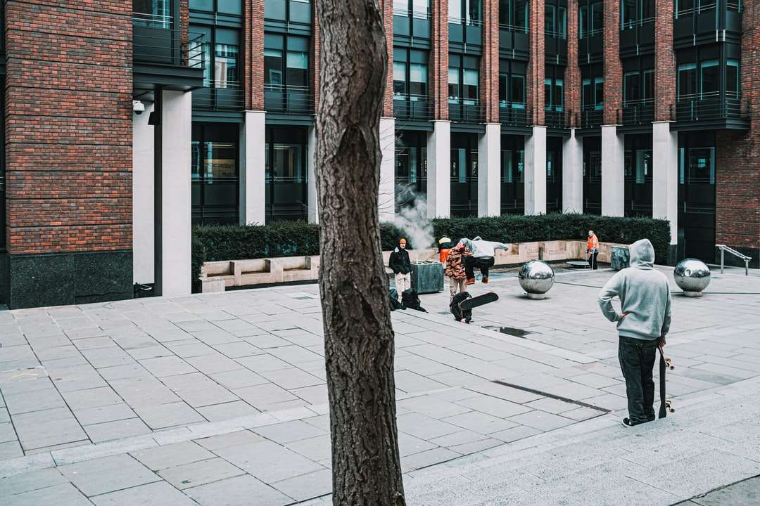 άνθρωποι που περπατούν στο πεζοδρόμιο κοντά σε καφέ γυμνά δέντρα online παζλ