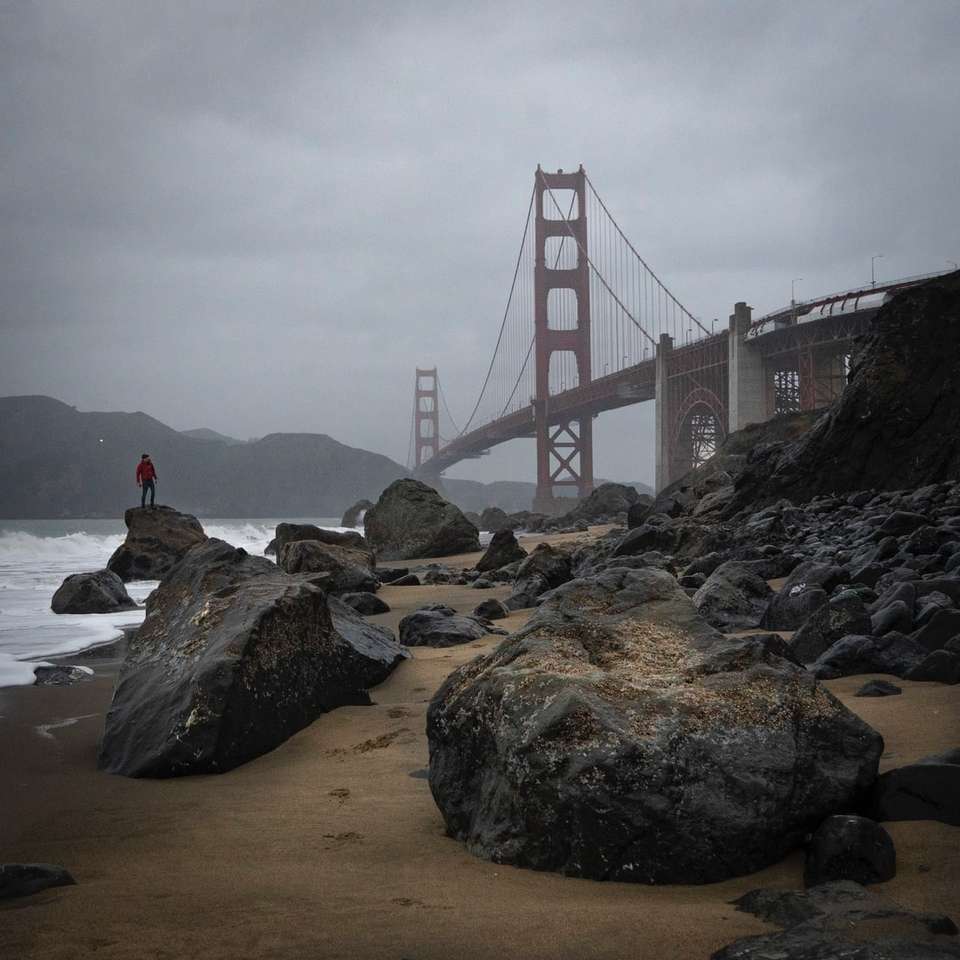 pessoa sentada na rocha perto da ponte Golden Gate quebra-cabeças online