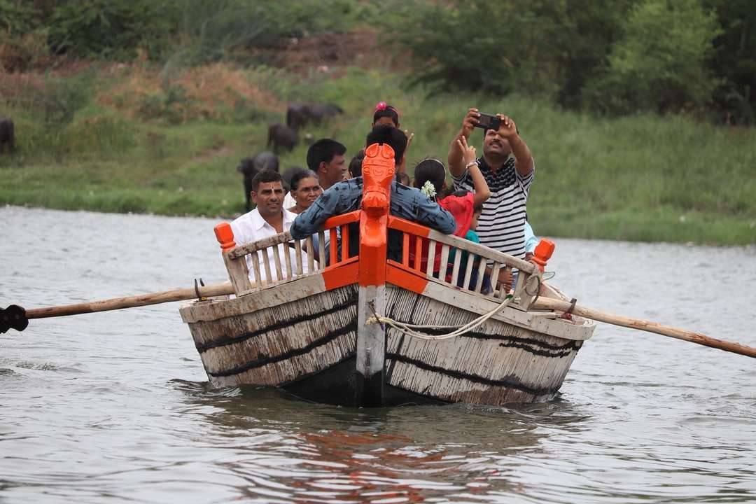 хора, каращи се на лодка по река през деня онлайн пъзел