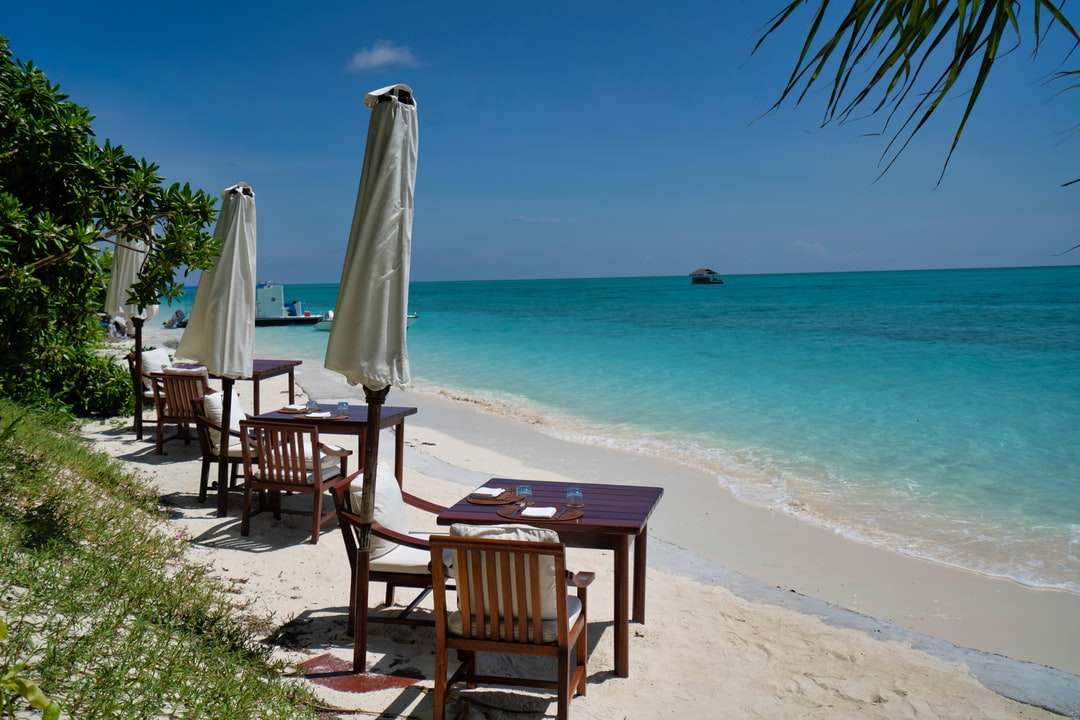 昼間のビーチで茶色の木製の椅子 ジグソーパズルオンライン