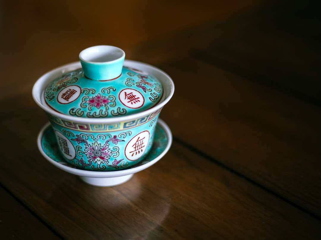 Taza de té de cerámica blanca, verde y rosa floral en platillo rompecabezas en línea