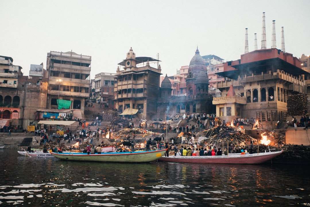 Personas que viajan en bote por el río cerca de edificios durante el día. rompecabezas en línea