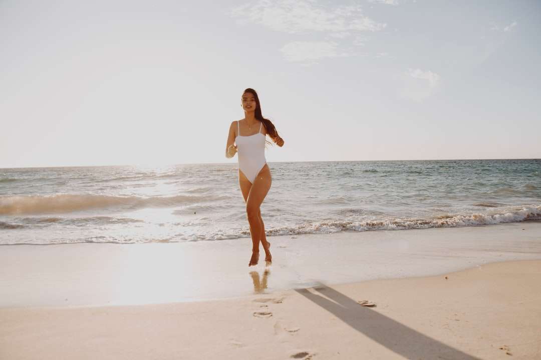 Frau im weißen Bikini, der tagsüber am Strand steht Puzzlespiel online