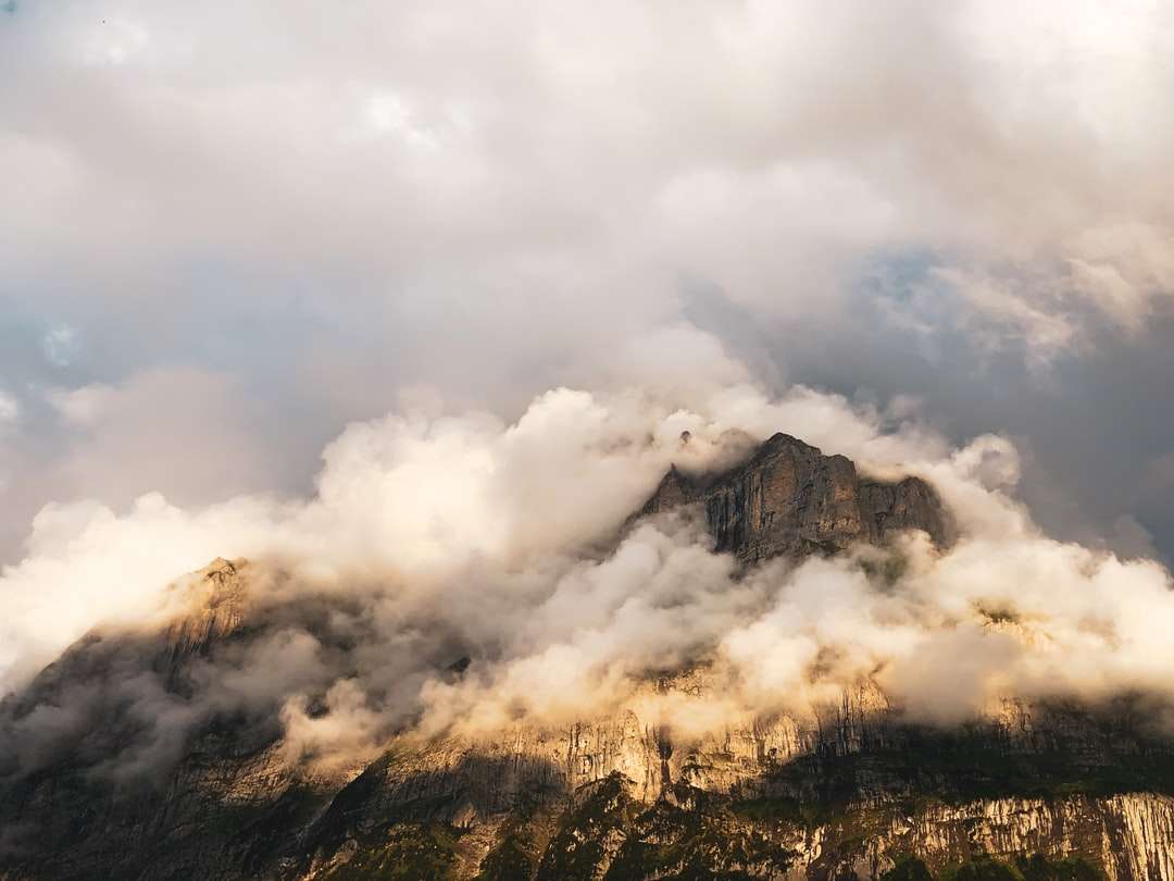 λευκά σύννεφα πάνω από το καφέ βουνό online παζλ