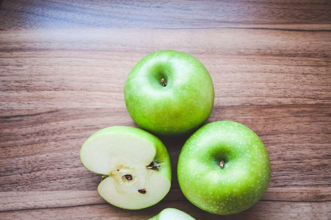 3 grüne Äpfel auf braunem Holztisch Online-Puzzle