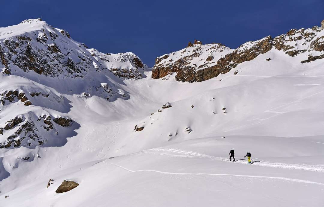 άνθρωποι που περπατούν σε χιονισμένο βουνό κατά τη διάρκεια της ημέρας online παζλ