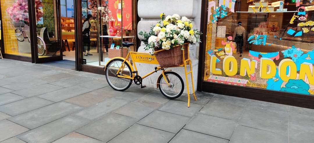 κίτρινο ποδήλατο πόλης με καλάθι με λουλούδια online παζλ