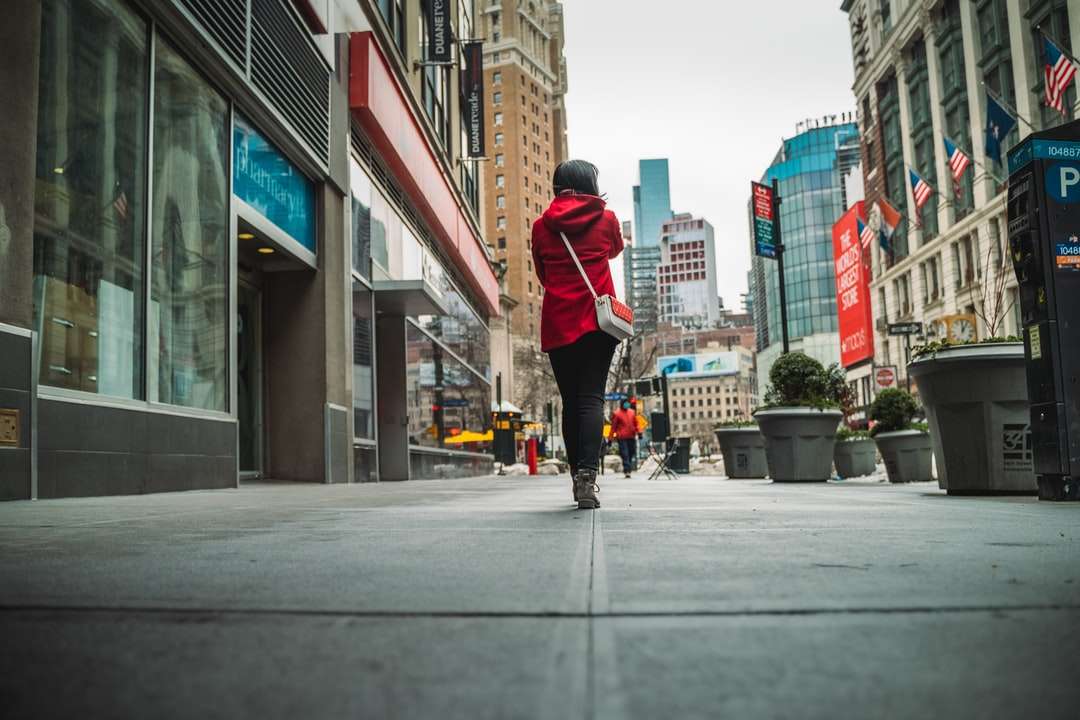 мъж в червено яке и черни панталони, ходещ по тротоара онлайн пъзел