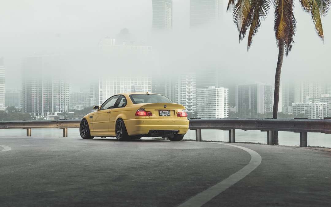 žlutý sedan na silnici poblíž městských budov během dne skládačky online