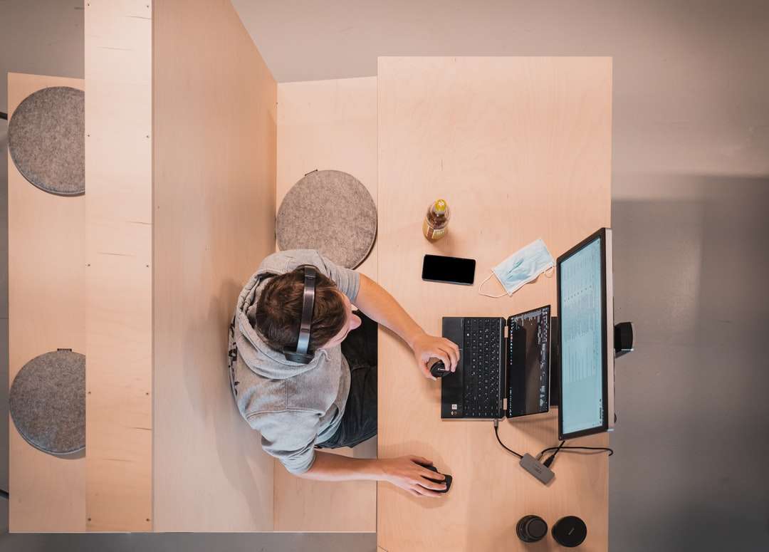 жена в синя риза, седнала на стол, използвайки преносим компютър онлайн пъзел