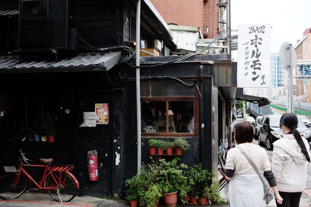 жена в бяло яке, стоящо близо до кафяв дървен магазин онлайн пъзел