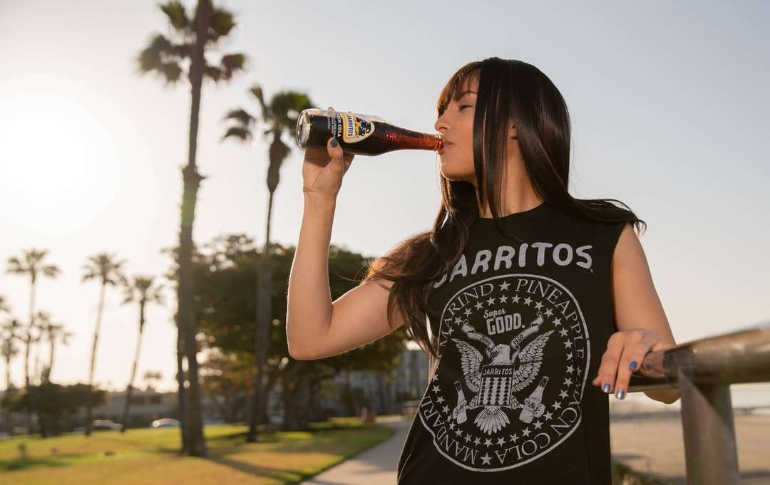kvinna i svartvitt linne som dricker coca cola Pussel online