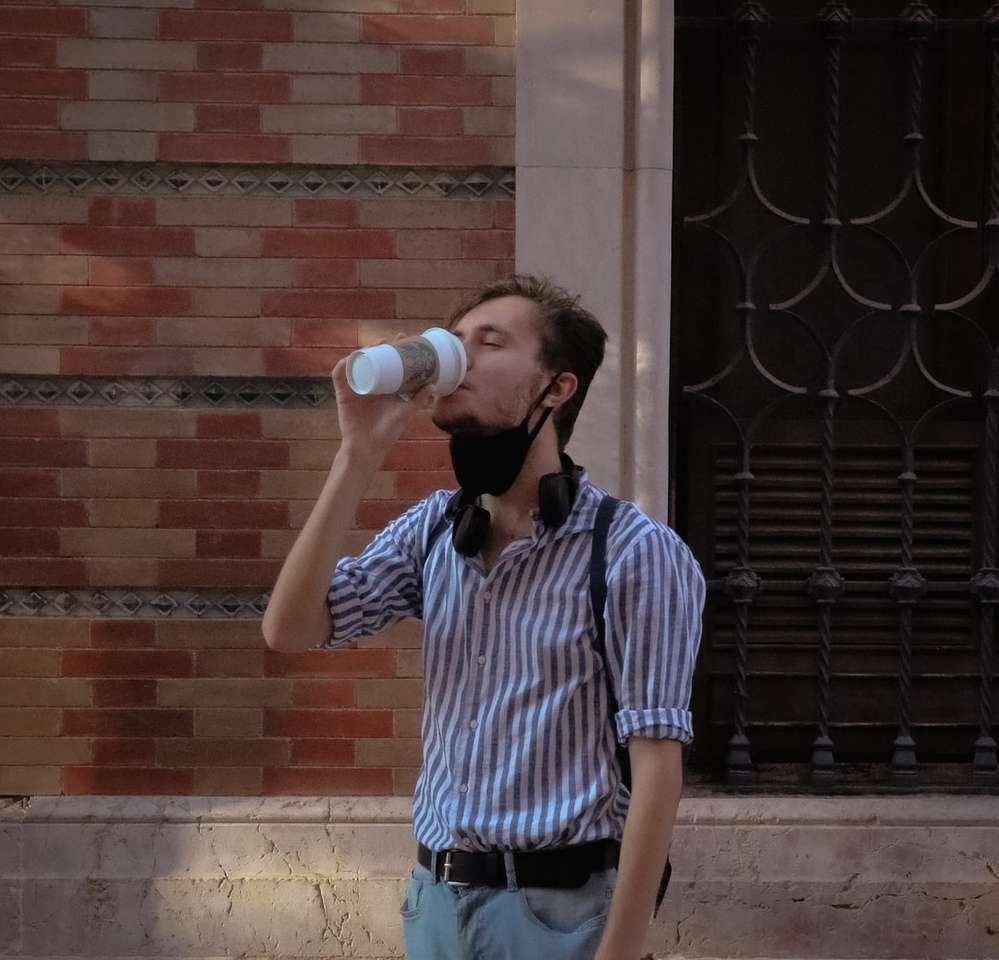 homem com camisa de botão listrada azul e branca bebendo puzzle online