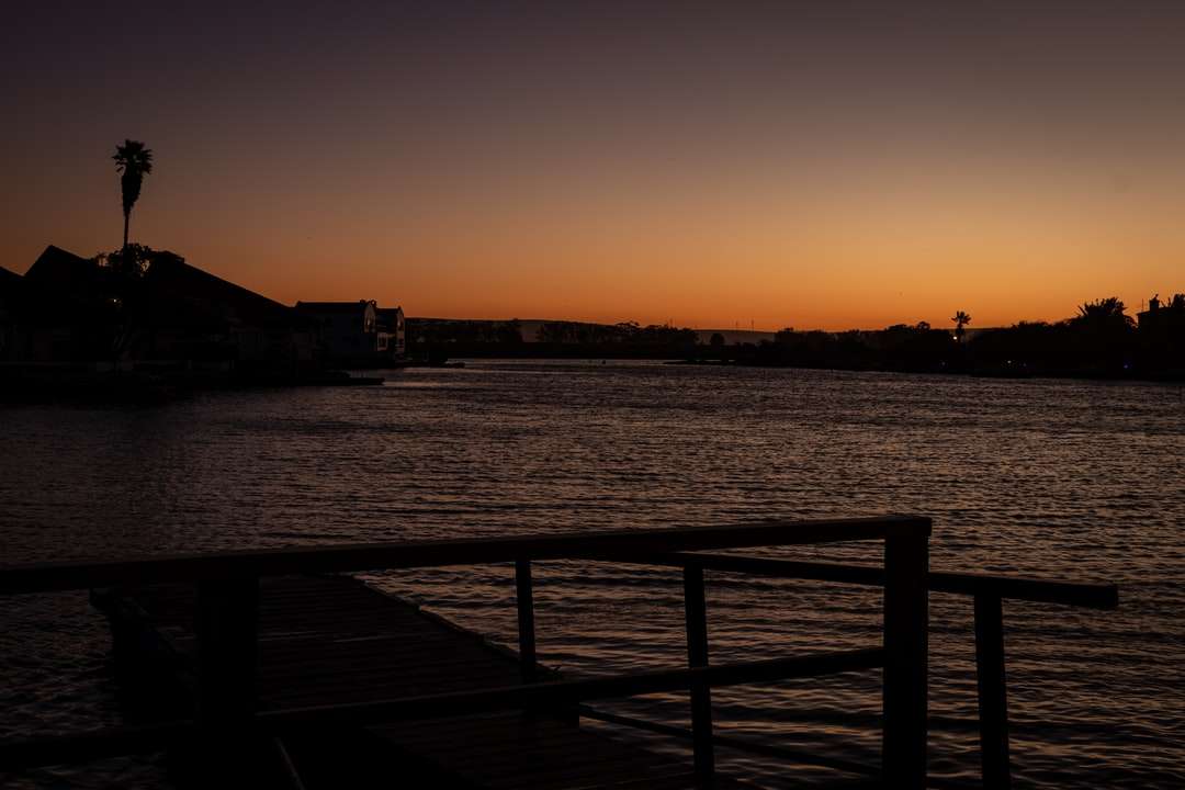 silhouet van een persoon die tijdens zonsondergang op een dok staat legpuzzel online