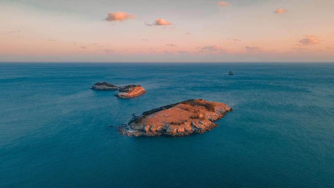 кафява скална формация върху синьо море под синьо небе онлайн пъзел