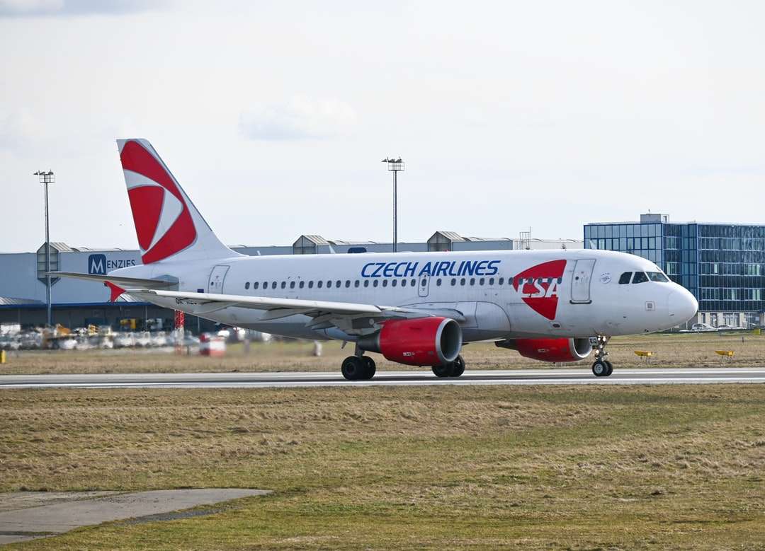 avião de passageiros branco e vermelho em campo marrom durante o dia puzzle online
