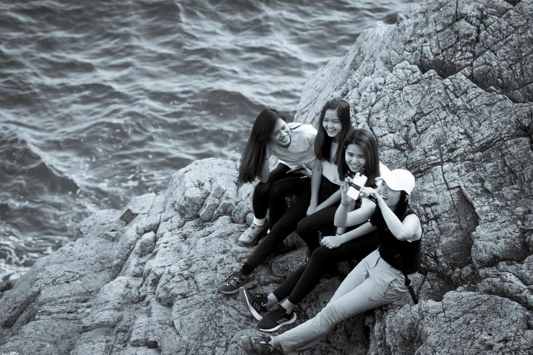 2 жени, седнали на скала близо до водоема през деня онлайн пъзел