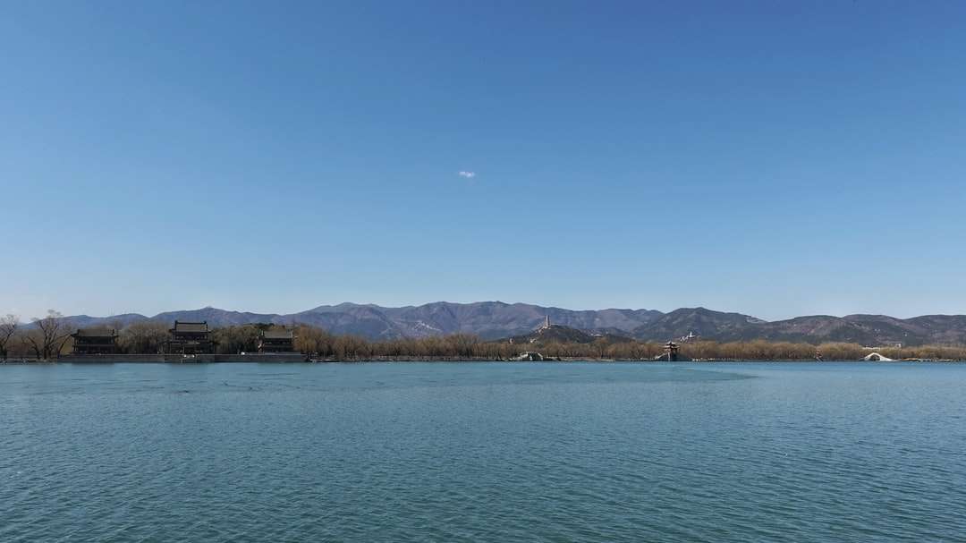 vodní útvar poblíž hory pod modrou oblohou během dne skládačky online