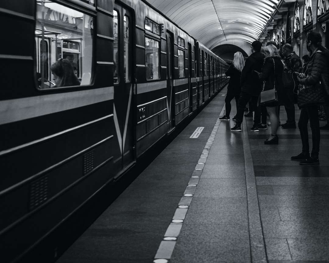 Foto en escala de grises de personas caminando en la estación de tren rompecabezas en línea