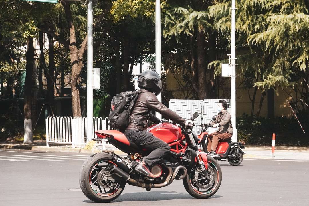 Hombre de chaqueta roja montando motocicleta roja en la carretera rompecabezas en línea