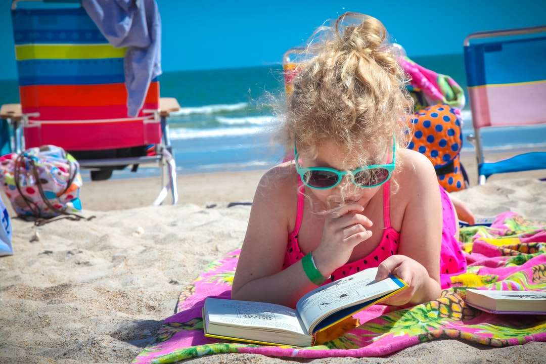 niña en rosa camiseta sin mangas con anteojos libro de lectura rompecabezas en línea
