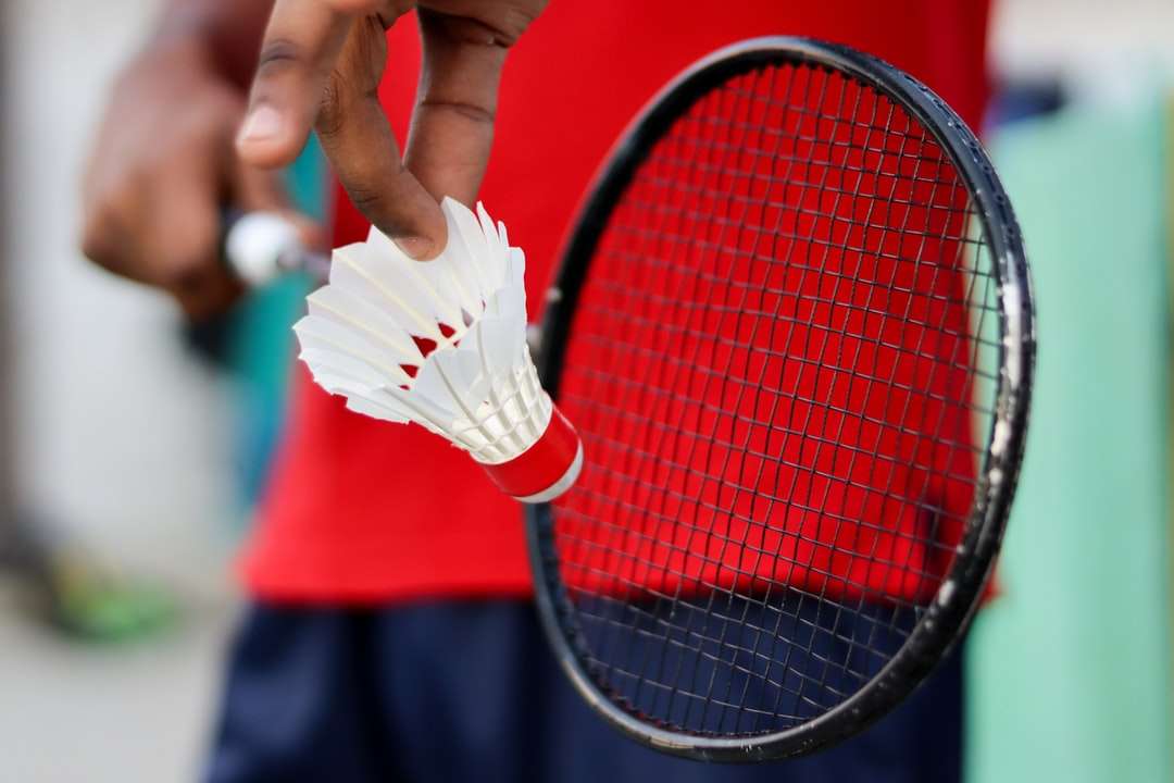 άτομο που κρατά κόκκινη και μαύρη ρακέτα τένις online παζλ