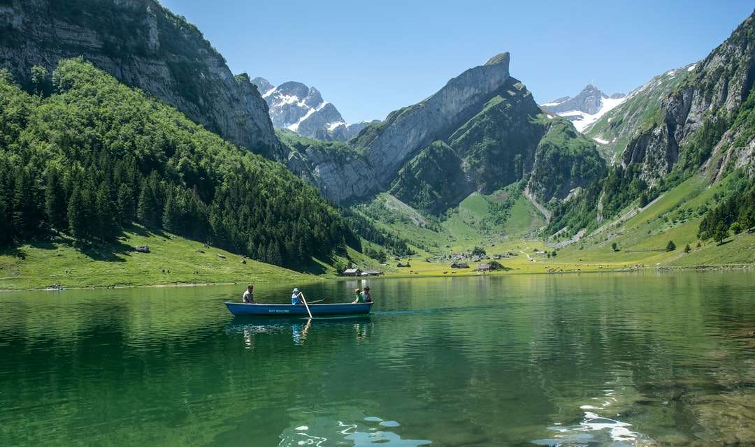 zelená loď na jezeře poblíž zelených hor během dne skládačky online