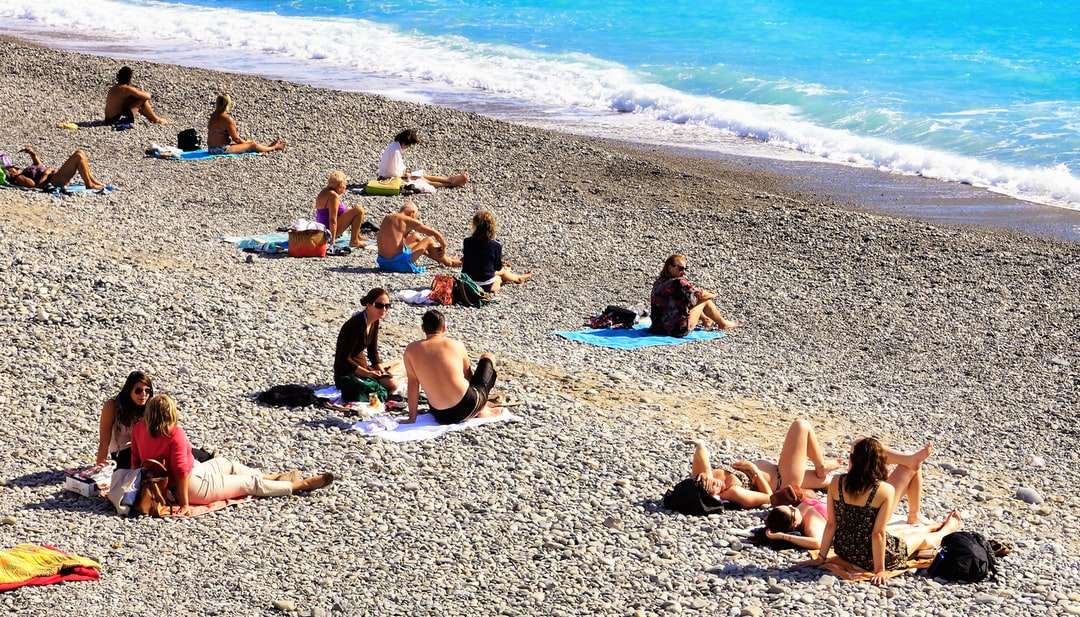 mensen zitten overdag op het strand legpuzzel online