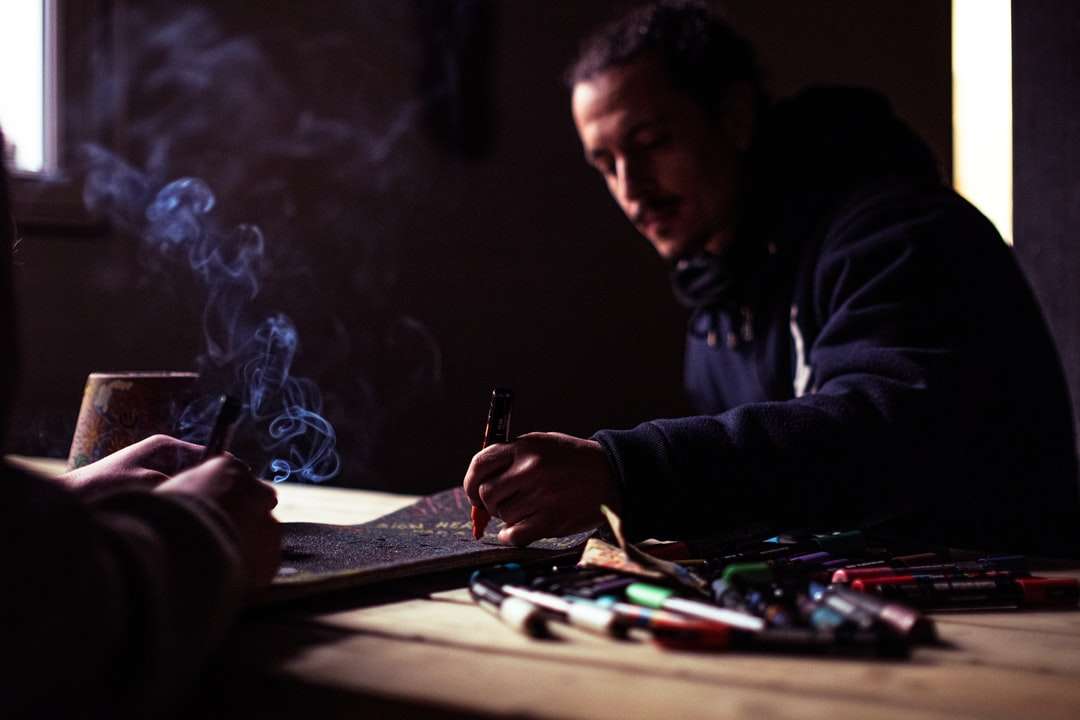 man in black jacket holding pen online puzzle