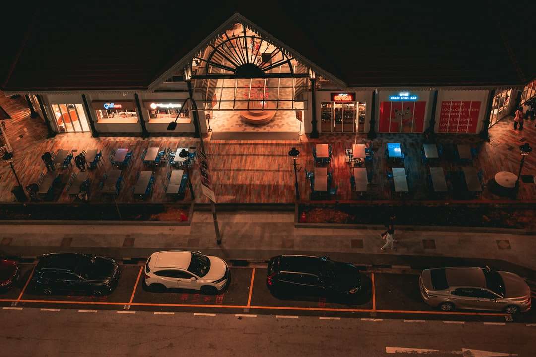 автомобили, припаркованные перед зданием в ночное время пазл онлайн