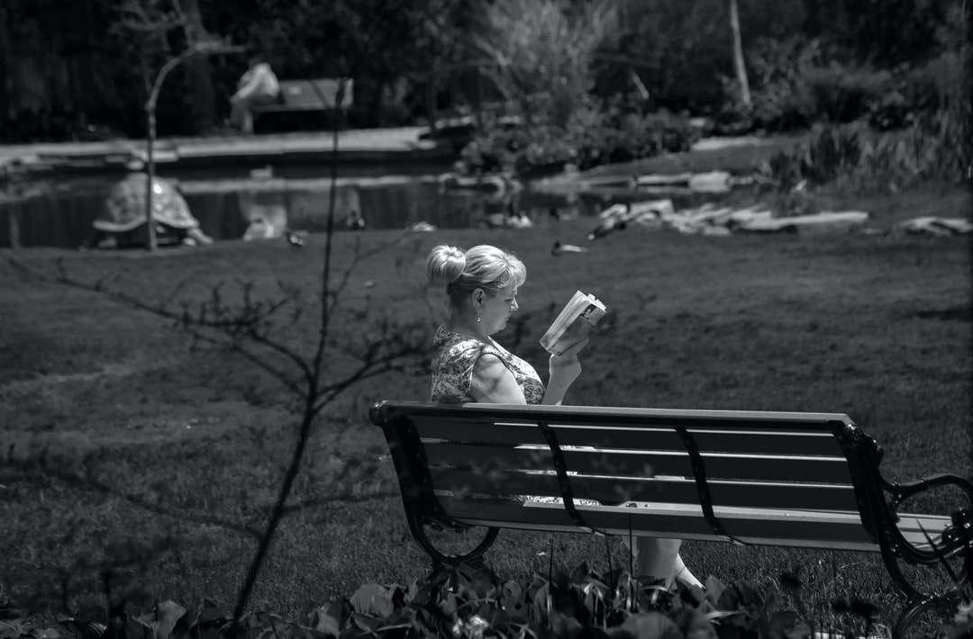 ragazza seduta su una panchina nella fotografia in scala di grigi puzzle online