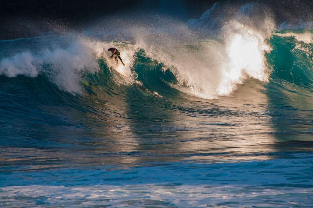 άντρας σερφ στα κύματα της θάλασσας κατά τη διάρκεια της ημέρας παζλ online