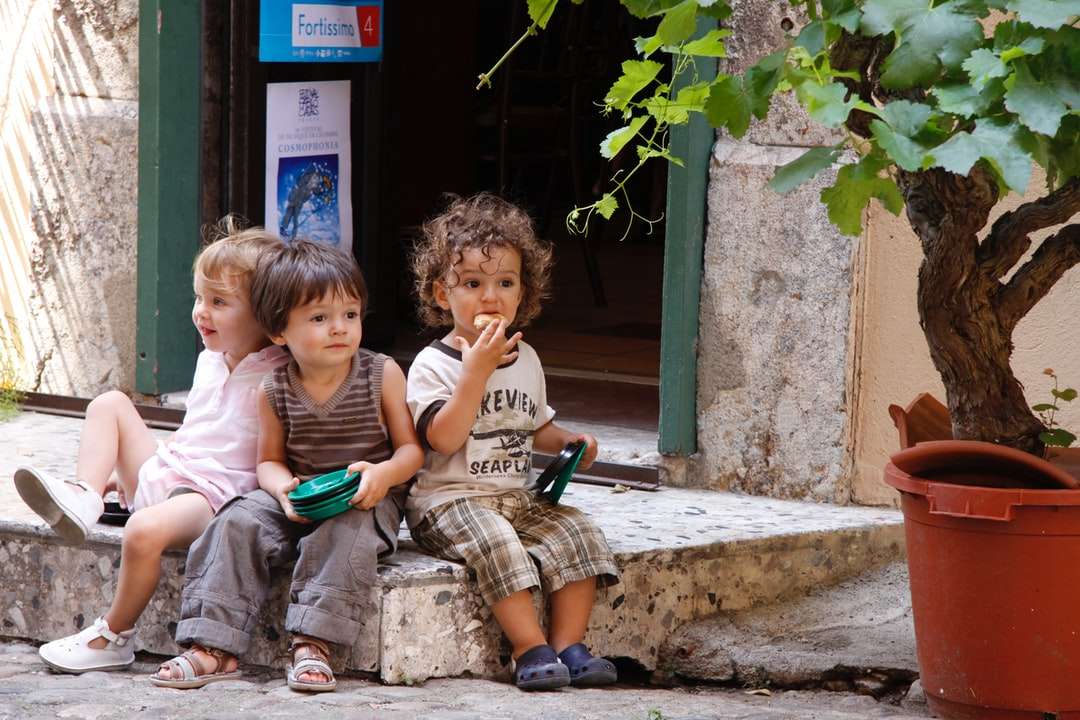 2 chlapci a dívka sedící na betonové lavici skládačky online